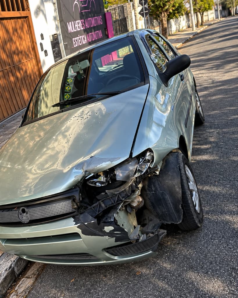 Fiat Palio com dianteira e lateral esquerda batidas e danificadas antes do reparo